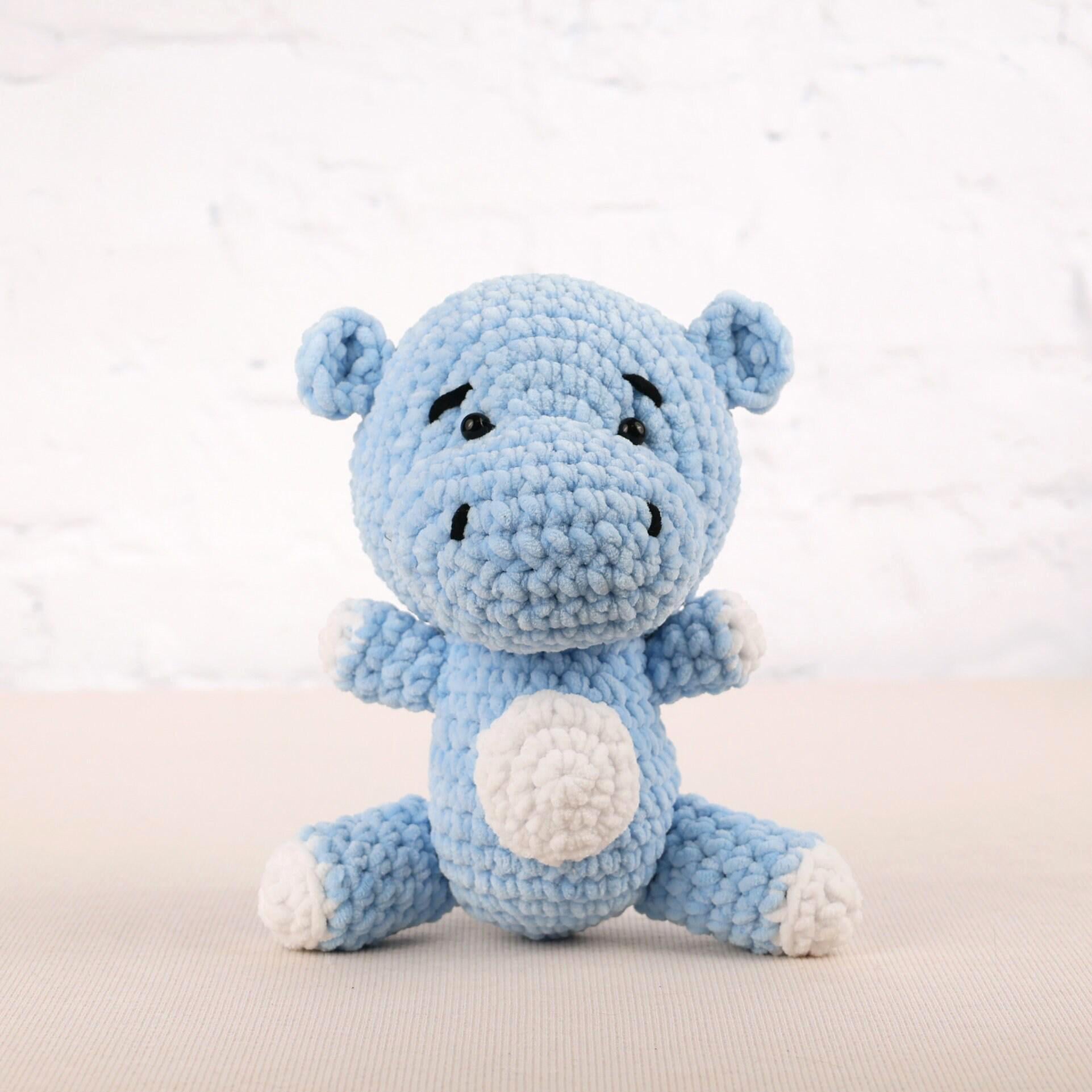 a blue crocheted stuffed animal sitting on a table